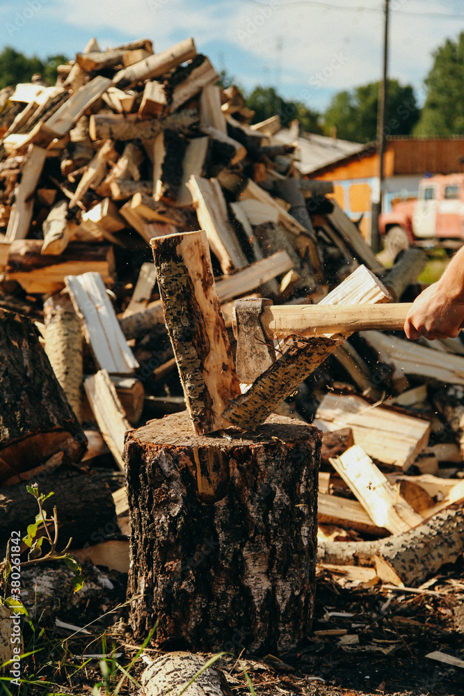 Hand holding an axe and hacking firewood Hand holding an axe and hacking firewood