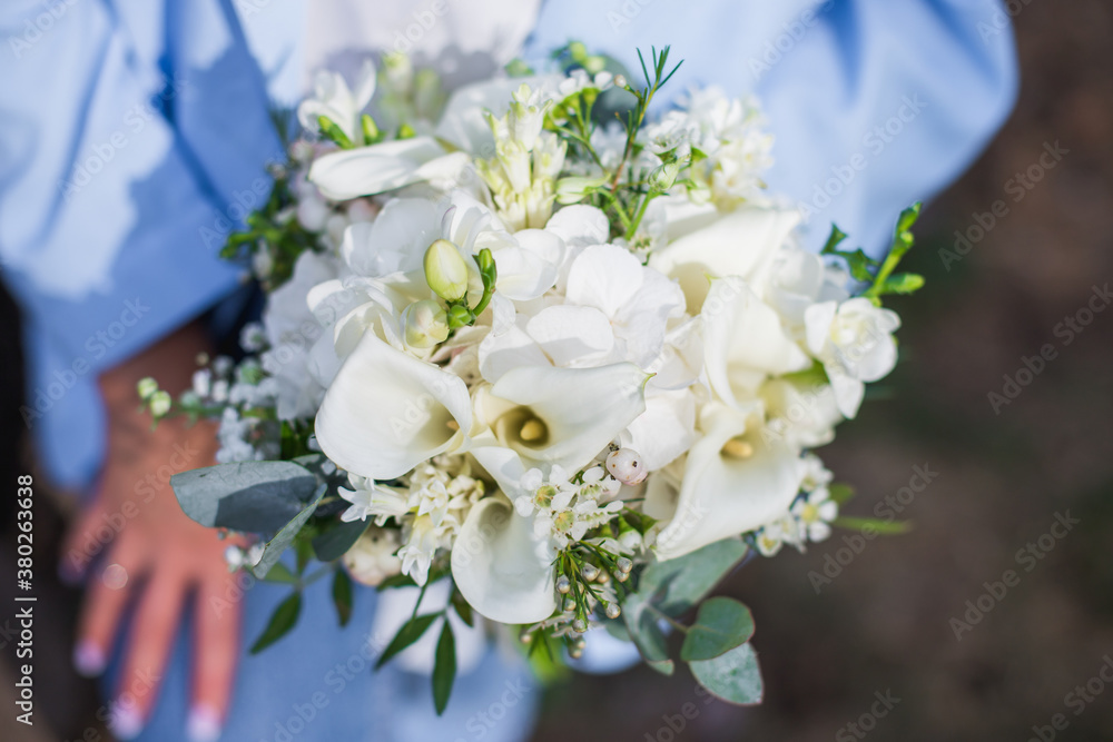 Wedding bouquet in bride hands. Roses, eustoma, eucalyptus in elegant bouquet. Summer and autumn flowers. Wedding bouquet in bride hands. Roses, eustoma, eucalyptus in elegant bouquet. Summer and autumn flowers.