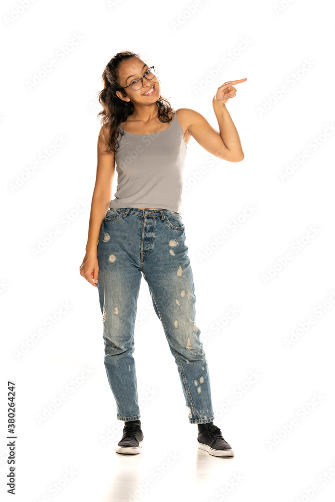 Young Indian woman in jeans pointing on white background Young Indian woman in jeans pointing on white background