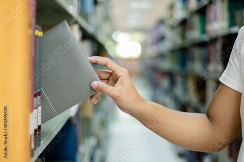 Young Asian women are searching for books and reading books on the tables and aisles of the college libraries to research and develop their academic and education self