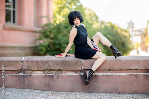 Junge Frau postet im schwarzen Kleid  im Freien  © SundGo