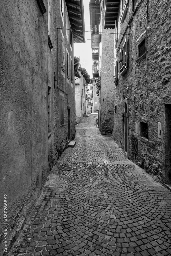 Detail of the old houses facades and alleys in Bagolino, a small town in the Lombardy Region (province of Brescia), famous for its Bagoss cheese made with goat's milk. Black and white. Detail of the old houses facades and alleys in Bagolino, a small town in the Lombardy Region (province of Brescia), famous for its Bagoss cheese made with goat's milk. Black and white.
