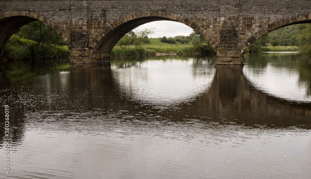 Brungerley bridge, Clitheroe. Large stone bridge over the river Ribble with reflections in the water
