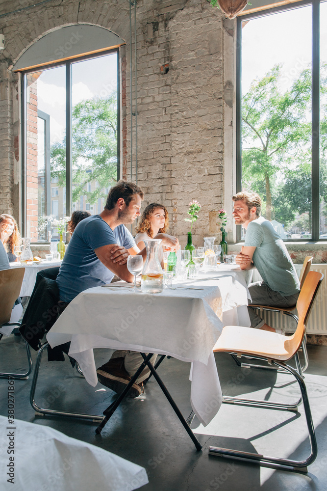 Young People Talking Over Drinks in a Trendy Restaurant