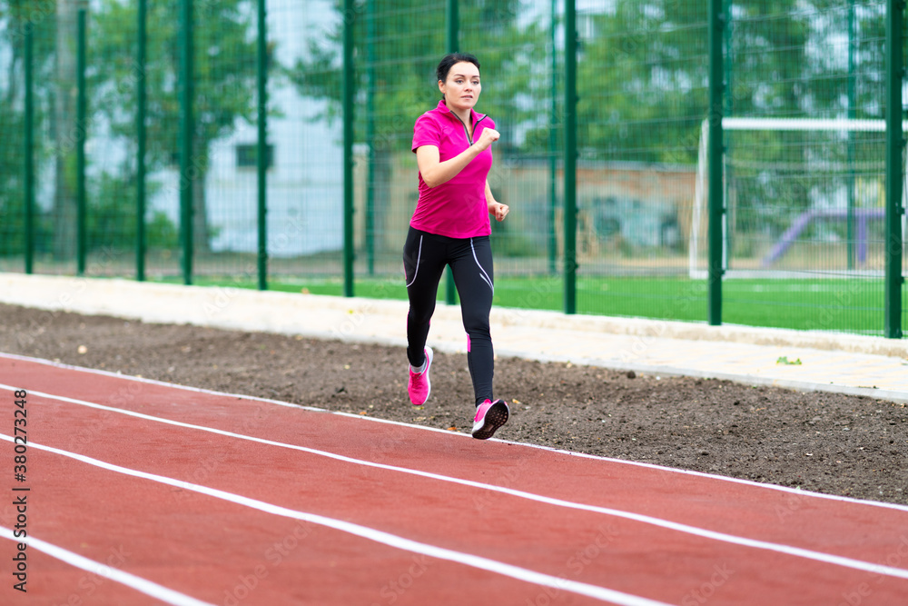 Woman runner training outdoors on a race track