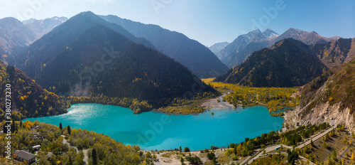 Autumn panorama of the Issyk mountain lake. Autumn mood. The turquoise lake is surrounded by mountains with yellowed trees. Kazakhstan © Alex Sipeta