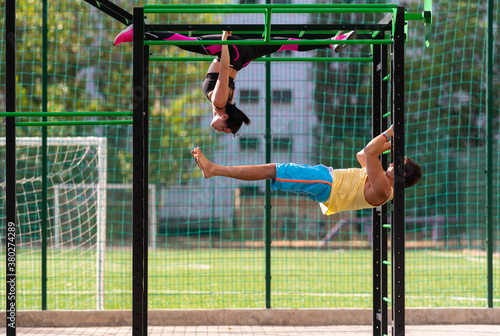 Young couple working out on parallel bars