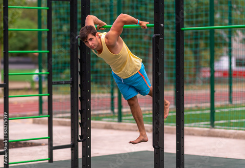 Fit young man working out at an outdoor gym