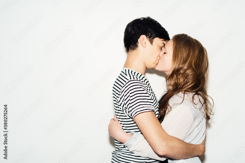 Couple kissing in front of a white background Couple kissing in front of a white background