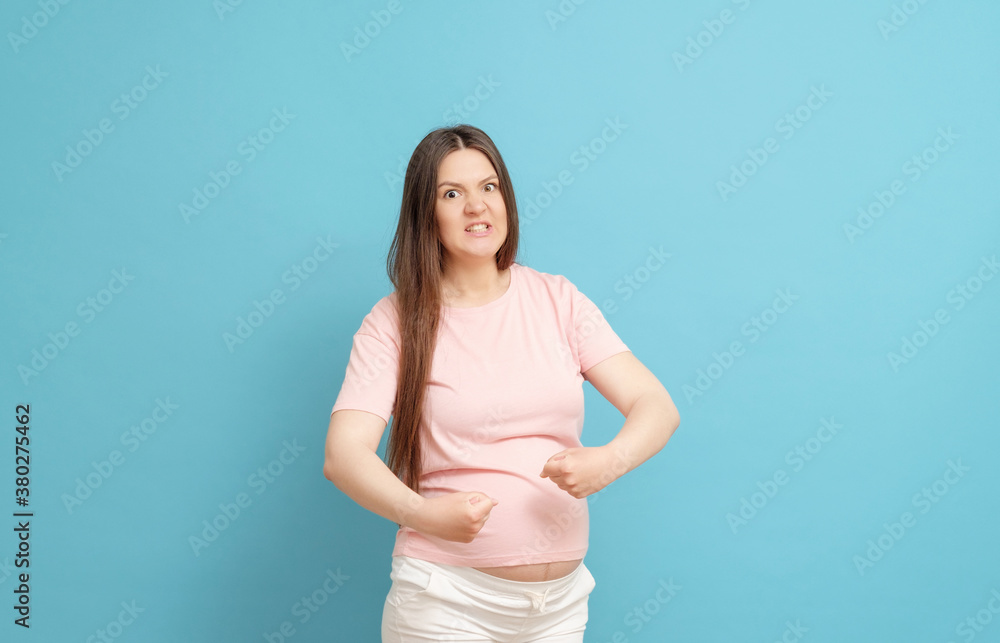 very aggressive pregnant woman on blue background very aggressive pregnant woman on blue background