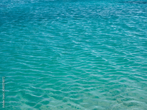 Turquoise rippled sea water surface background, texture