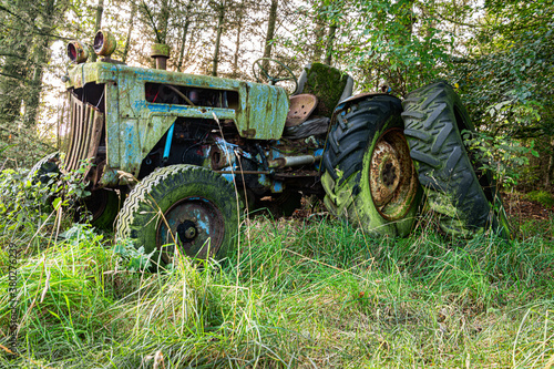 A rusty old disused tractor in woodland