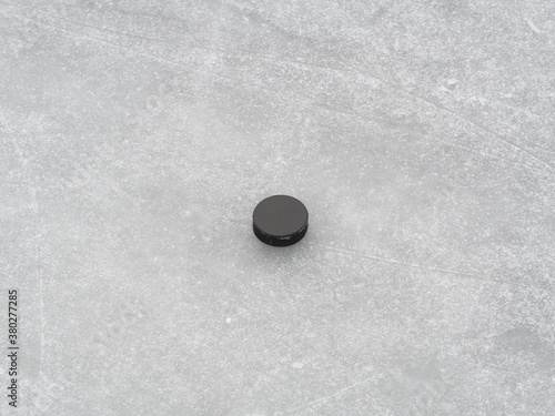 Puck on ice hockey rink surface, naturally frozen, winter sport background