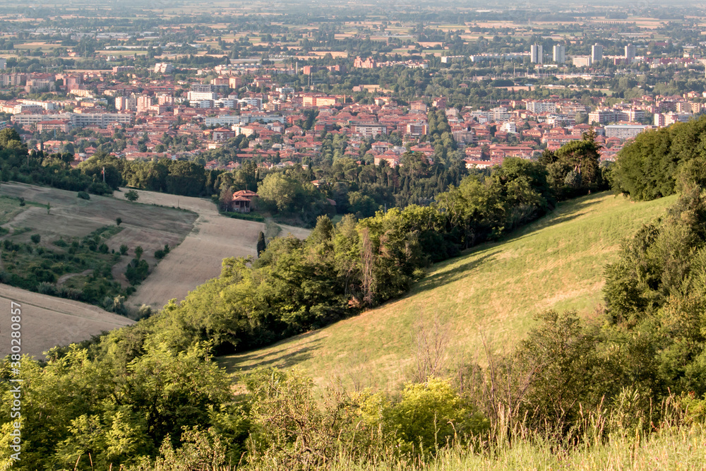 Panoramic view of Bologna from Bolognese hills. The city in background with rural fields and wheat in close up. Emilia Romagna Region, Italy