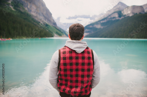 A hiker and traveler looking at turquoise blue water views at Lake Louse in Banff National Park photo