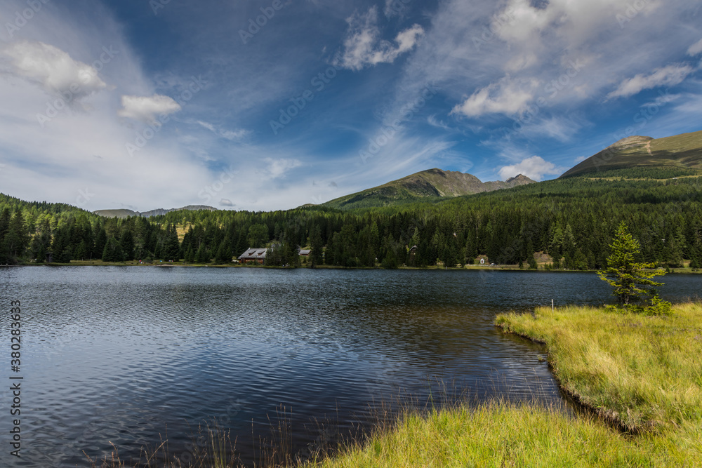 green landscape with blue sky at a mountain lake