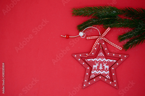 Red Christmas stars and a green branch of the Christmas tree on a red background. Christmas flatly. New year 2021.