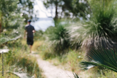 Nature track with unrecognisable man walking in the distance photo