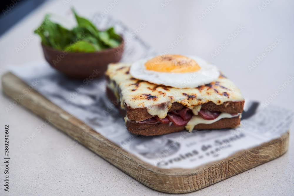 Hot sandwich with sausage and cheese under fried egg Hot sandwich with sausage and cheese under fried egg
