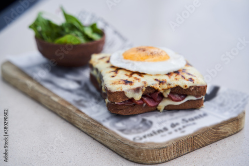 Hot sandwich with sausage and cheese under fried egg