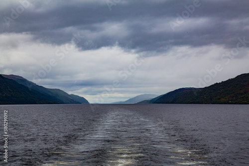 Vista de turbulencia de aguas sobre lago con montañas oscuras al fondo