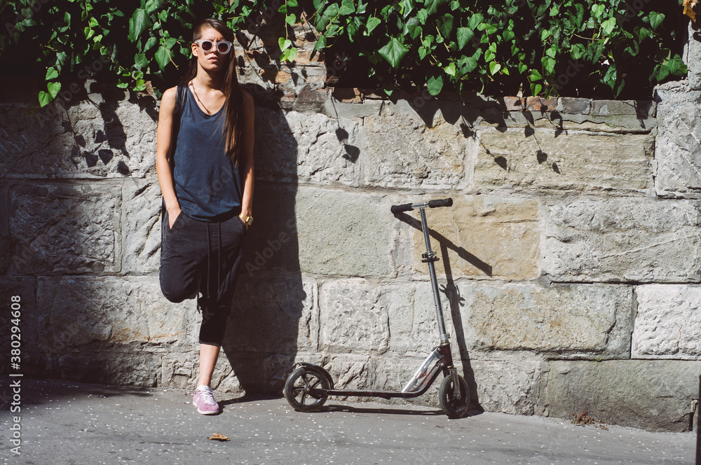 Beautiful brunette girl standing by her scooter Beautiful brunette girl standing by her scooter