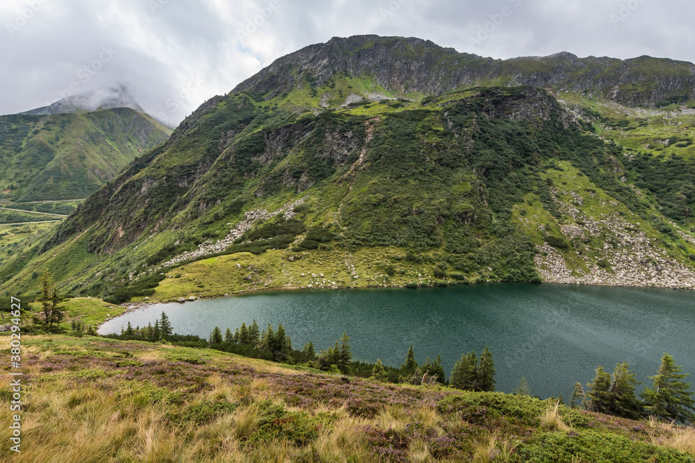 mountain lake with hillslope in green mountains