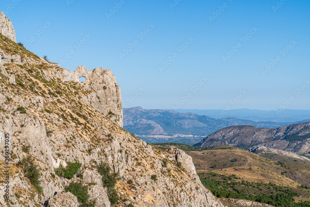 Forata rock hole with the city of Cocentaina in the background, Aitana mountain.