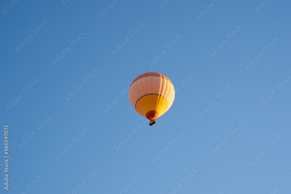 Naklejka premium Large yellow and orange hot air balloon flew over the Love Valley in the Göreme National Park. Cappadocia, Turkey.