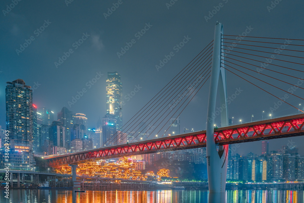 Obraz premium Night view of the Qiansimen bridge and the skyline in Chongqing, China.