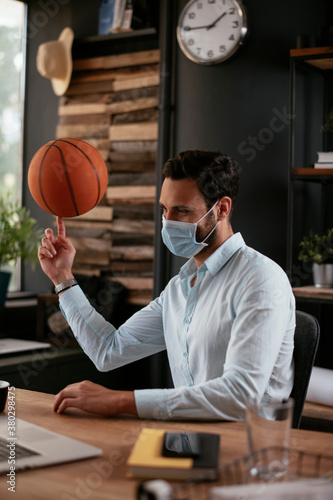 Businessman with medical mask. Handsome businessman having fun while working in office...