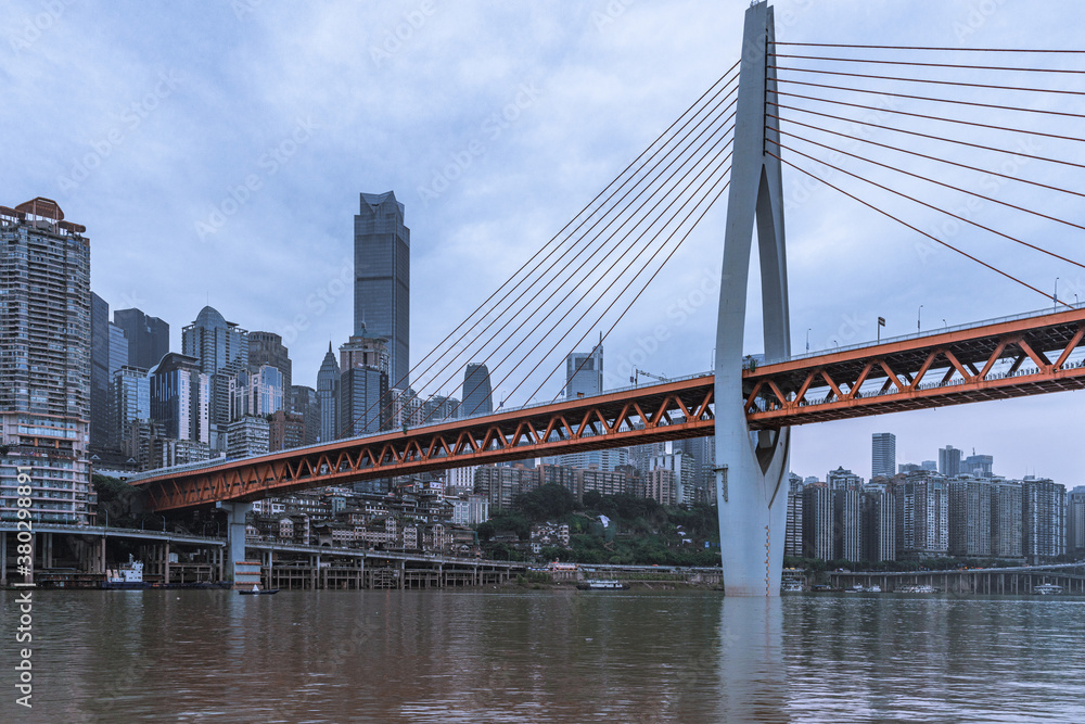 Fototapeta premium Panorama view of the Qiansimen bridge and skyline in Chongqing, China, on a cloudy day.