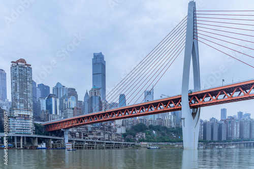 Panorama view of the Qiansimen bridge and skyline in Chongqing, China, on a cloudy day.