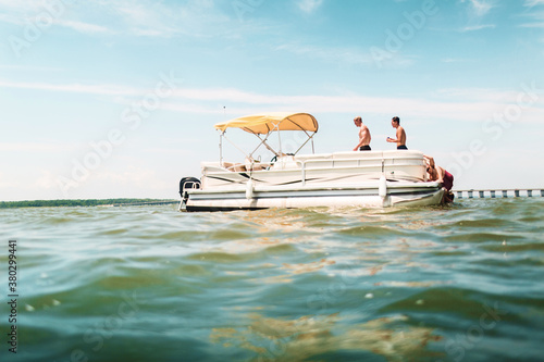 Friends hanging out on a pontoon boat in the ocean