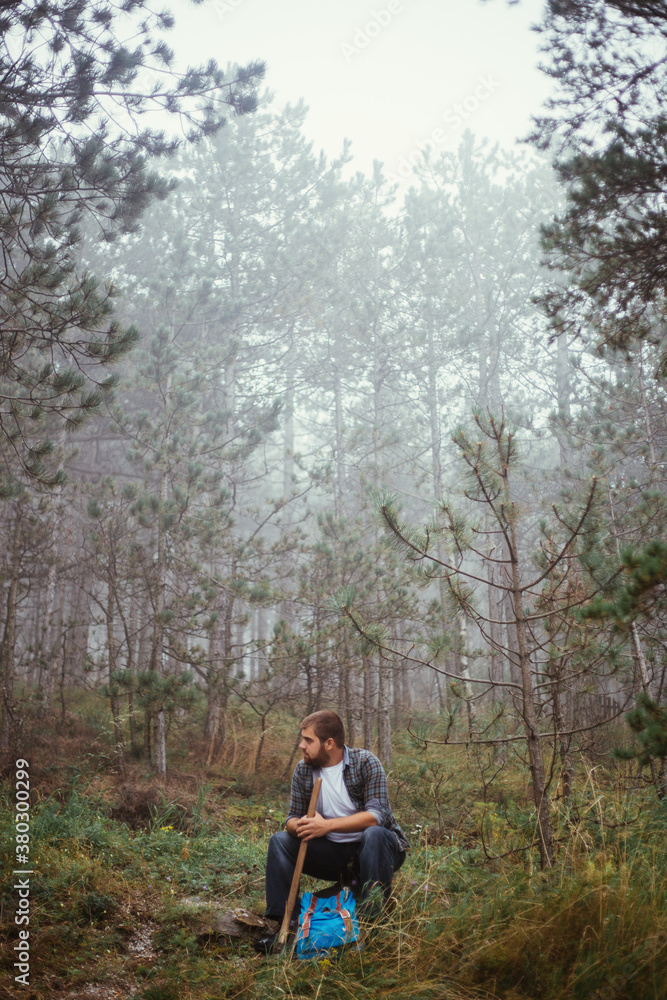 Young lumberjack having a rest in forest Young lumberjack having a rest in forest