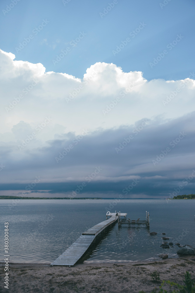 Dark Stormy Clouds with Silver Lining Over Calm Lake Dark Stormy Clouds with Silver Lining Over Calm Lake
