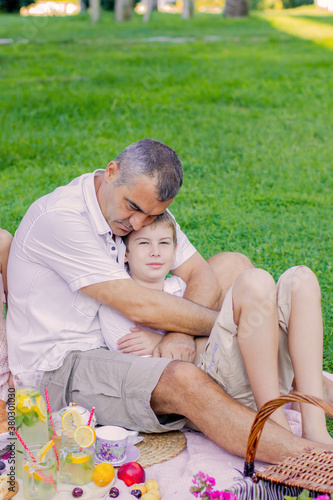 Beautiful family in the summer on a picnic in a green park.