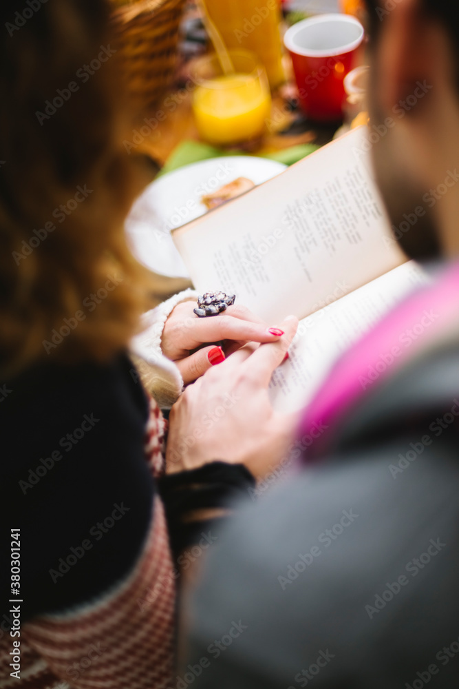Young couple reading a book outdoors