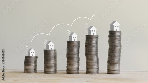 The coins that are stacked in a graph with home on top and growing arrow symbol motion.