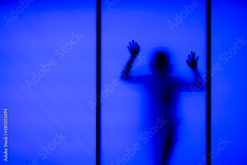 Silhouette of a woman behind the glass