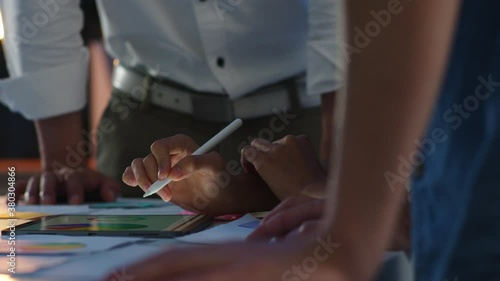 Group of Asia young creative people in smart casual wear discussing business brainstorming meeting ideas mobile application software design project in modern night office. Coworker teamwork concept.