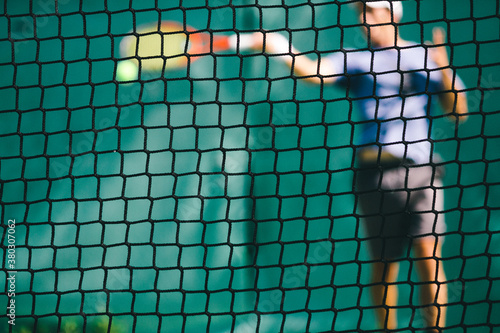Tennis player hitting a ball in a tennis court during a sunny day photo