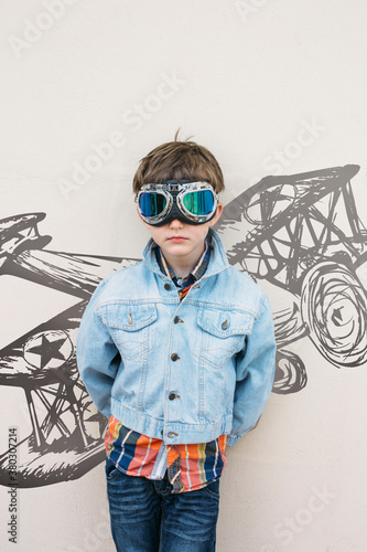 Portrait of a boy in goggles in front of an aeroplain mural photo