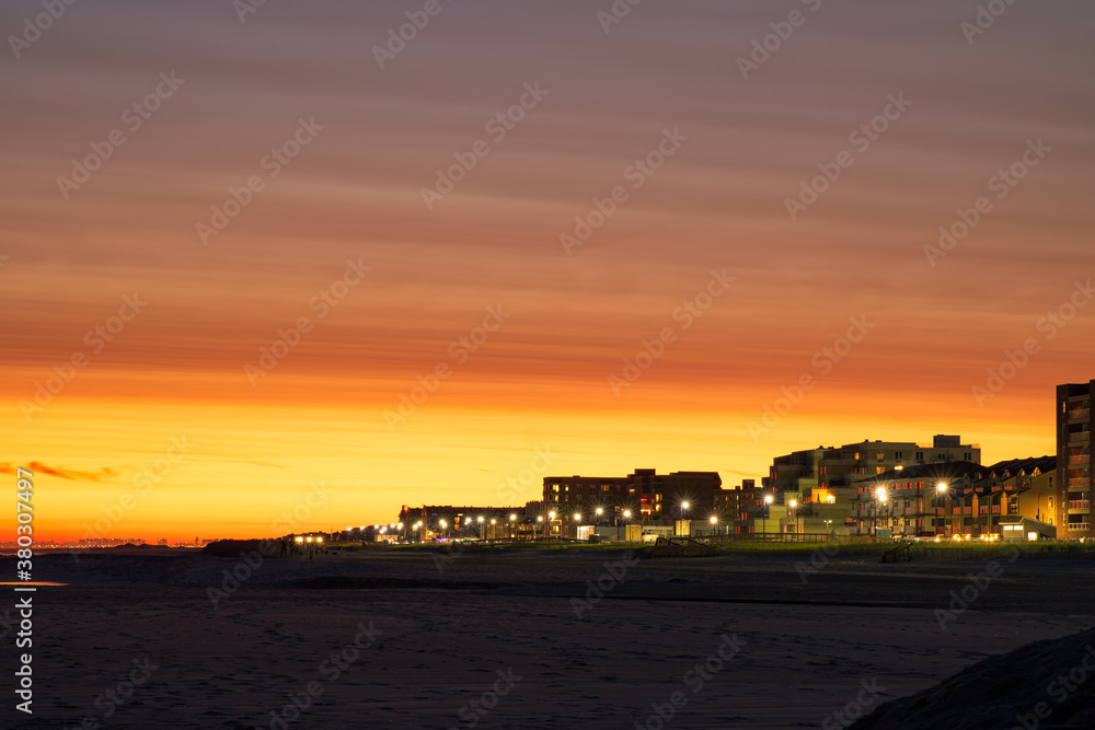 Looking down the beach at sunset, with the Long Beach boardwalk stretching off into the distance. Long Beach NY 