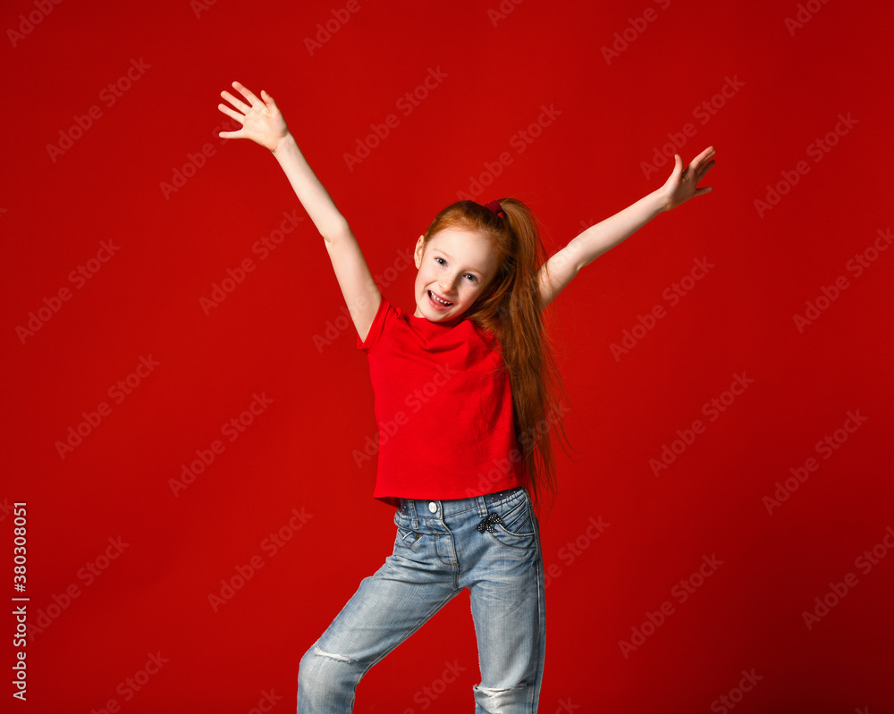 Portrait of a young girl with red hair smiling at camera with hands in the air Portrait of a young girl with red hair smiling at camera with hands in the air