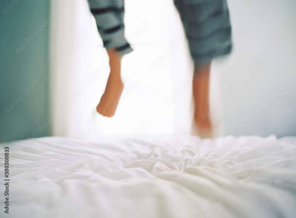 Feet of a child jumping on the bed Feet of a child jumping on the bed