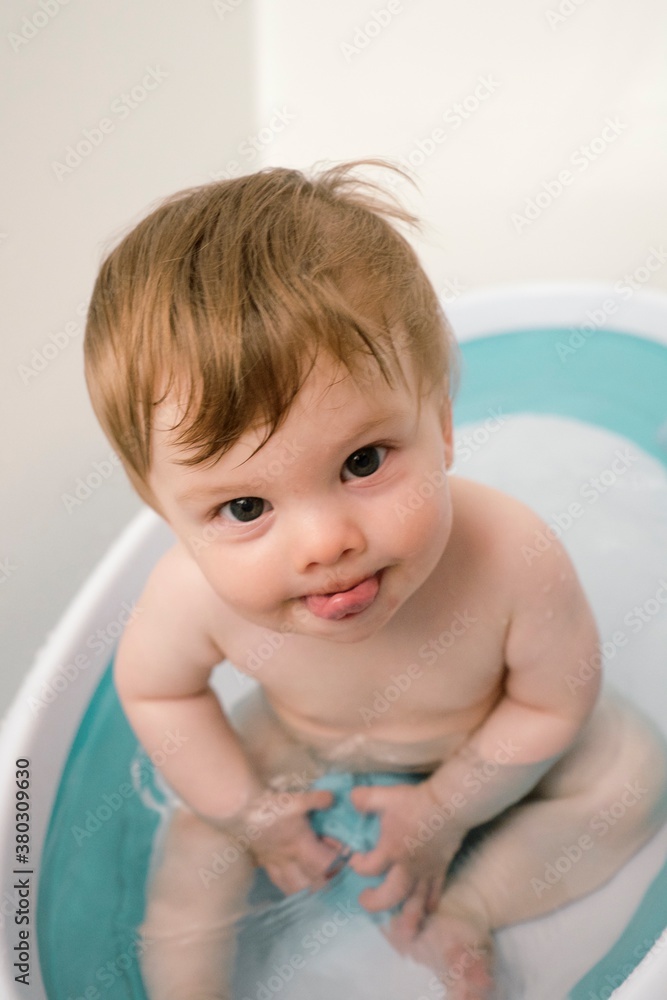 Baby boy smiling whiling taking a bath in a tub. Baby boy smiling whiling taking a bath in a tub.
