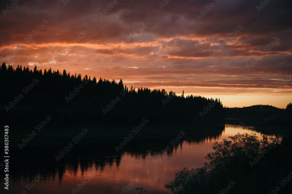 pink sunset over the river in the forest