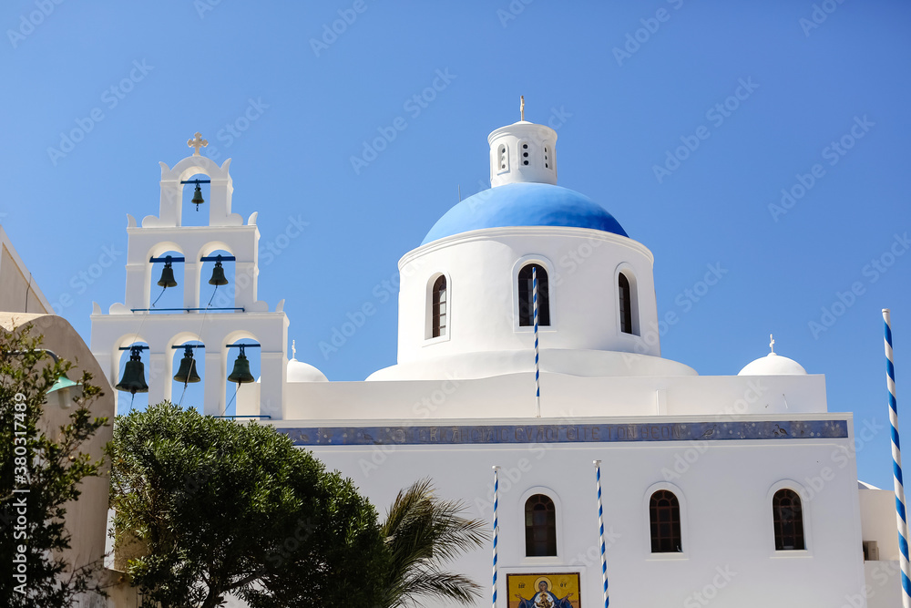 The Christian Church is white and blue against the sky.Cathedral in Greece on the island of Santorini.Summer travel.European architecture.selective focus