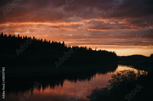 pink sunset over the river in the forest